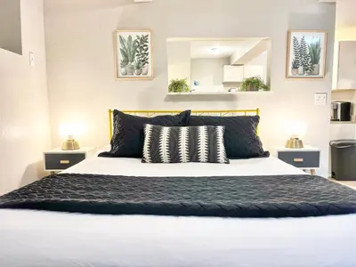 a bedroom with a large bed with black and white pillows at Urban Oasis near the Zoo A Central Studio for 2 in San Diego