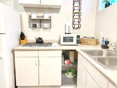 a kitchen with white cabinets and a sink and a microwave at Urban Oasis near the Zoo A Central Studio for 2 in San Diego
