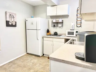 a kitchen with white cabinets and a refrigerator at Urban Oasis near the Zoo A Central Studio for 2 in San Diego