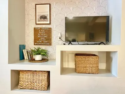 a living room with a tv and wicker baskets at Urban Oasis near the Zoo A Central Studio for 2 in San Diego