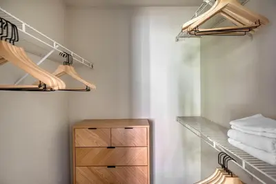 a walk in closet with a wooden cabinet and towels at Rancho Penasquitos 1br w pool gym nr bars SAN-31 in San Diego