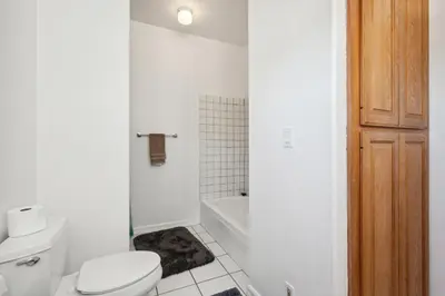 a white bathroom with a toilet and a bath tub at Coastal Haven in Oceanside- Cozy Beach Getaway home in Oceanside