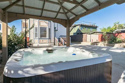 a hot tub in a backyard with a pergola at Coastal Haven in Oceanside- Cozy Beach Getaway home in Oceanside