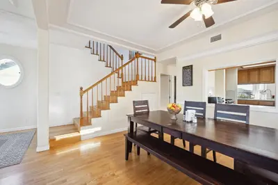 a living room with a dining room table and a staircase at Coastal Haven in Oceanside- Cozy Beach Getaway home in Oceanside