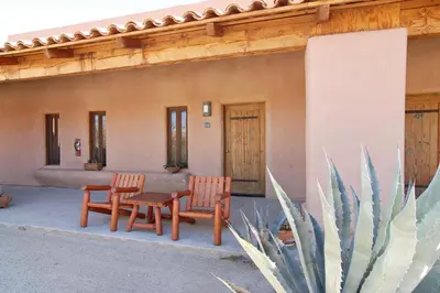 two chairs and a table in front of a building at Borrego Valley Inn in Borrego Springs