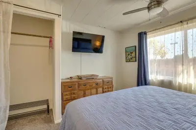 a bedroom with a bed and a flat screen tv at Downtown Carlsbad Apartment Less Than half Mi to Beach! in Carlsbad