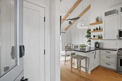 a kitchen with white cabinets and a black counter top at Neptune Hidden Gem in Encinitas