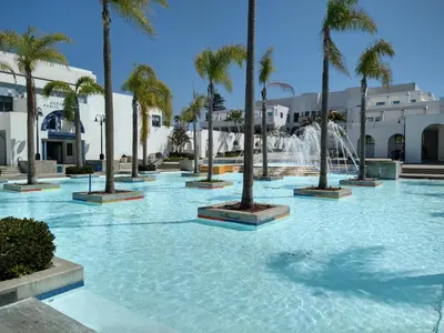 a pool with palm trees and a fountain at Charming 1Bedroom Vacation Condo in Oceanside