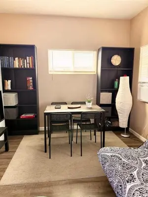 a living room with a table and chairs in it at The studio apartment in Clairemont - New AC unit in San Diego