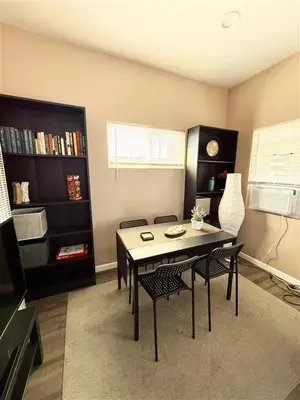 a room with a table and chairs and a book shelf at The studio apartment in Clairemont - New AC unit in San Diego