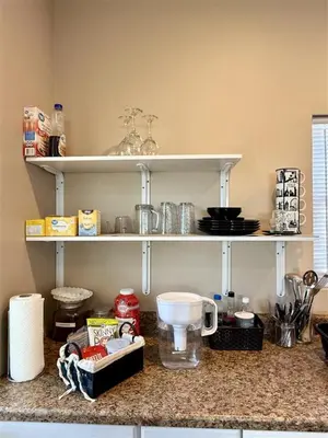 a kitchen counter with shelves on the wall at The studio apartment in Clairemont - New AC unit in San Diego