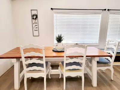 a dining room table with white chairs and a wooden table at The Blue Cove in Hemet