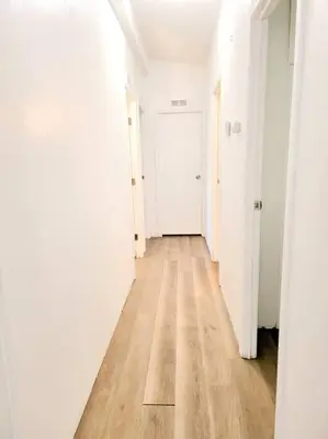 an empty hallway with white walls and a wooden floor at The Blue Cove in Hemet