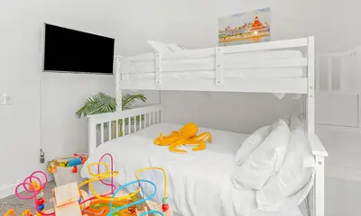 a white bedroom with a bunk bed with a toy on it at Villa Descanso in Oceanside