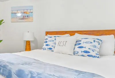a bed with blue and white pillows on it at Villa Descanso in Oceanside