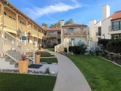 a walkway in front of some apartment buildings at Casa De La Playa in San Diego