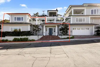 a large white house with red poles in front of it at Coastal La Jolla Luxury - AC & Large Ocean View Patio! in San Diego