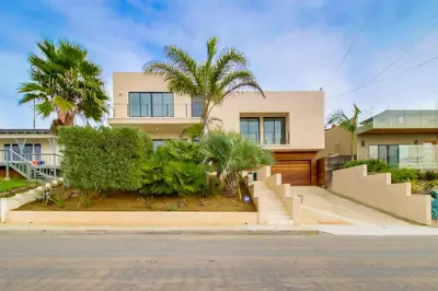 a house with palm trees in front of it at Sunset Cliffs Modern Luxury Estate w Ocean Views, Oversized Spa, AC, Yard! in San Diego