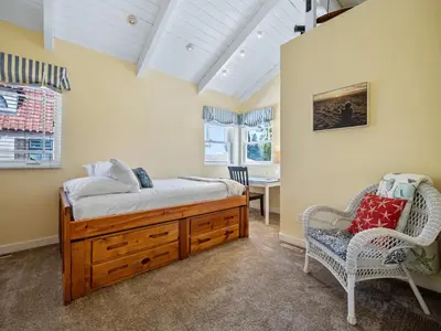 a bedroom with a bed and a chair and a table at Stunning beach home - steps2sand, AC, Large Patio and Fast Wifi! in San Diego