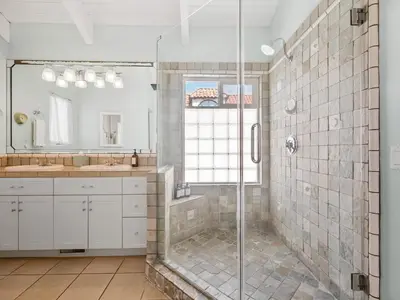 a bathroom with two sinks and a shower at Stunning beach home - steps2sand, AC, Large Patio and Fast Wifi! in San Diego
