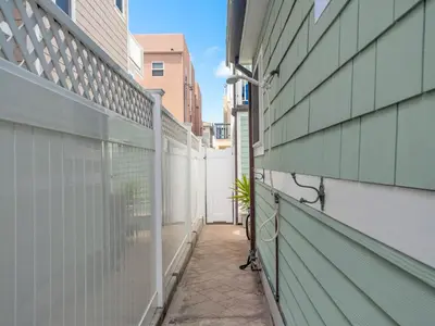 an empty alley between two buildings with a fence at Stunning beach home - steps2sand, AC, Large Patio and Fast Wifi! in San Diego