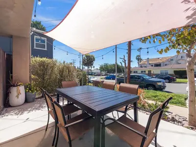 a wooden table and chairs on a patio at Pacific Beach Paradise - Near the Beach w AC, Garage, Fast Wifi & Private Patio! in San Diego