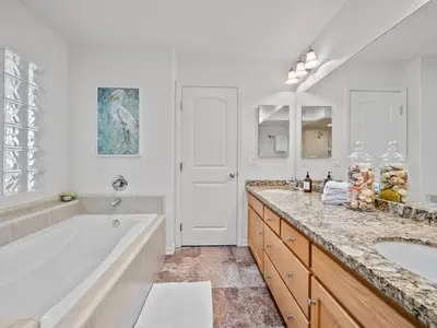a white bathroom with a tub and a sink at Pacific Beach Paradise - Near the Beach w AC, Garage, Fast Wifi & Private Patio! in San Diego