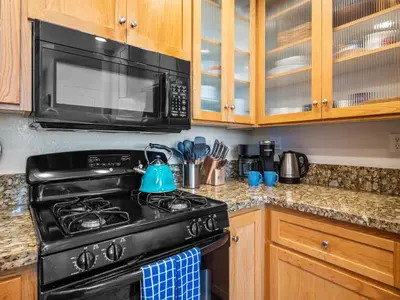 a kitchen with a black stove and a microwave at Pacific Beach Dreaming - AC, walk 2 town, garage & beach in San Diego