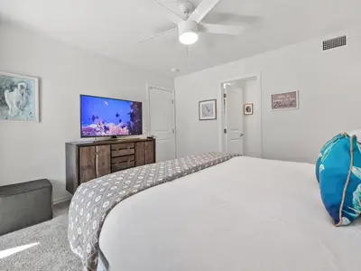a bedroom with a large bed and a flat screen tv at Pacific Beach Dreaming - AC, walk 2 town, garage & beach in San Diego