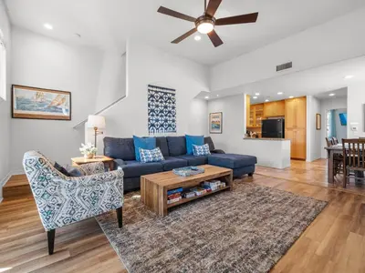 a living room with a blue couch and a table at Pacific Beach Dreaming - AC, walk 2 town, garage & beach in San Diego