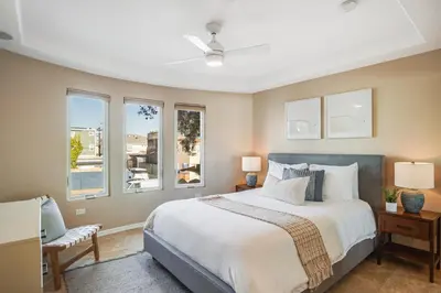 a bedroom with a large bed and windows at Massive Dream Beach Home - Dog Friendly, AC, Steps2Sand in San Diego