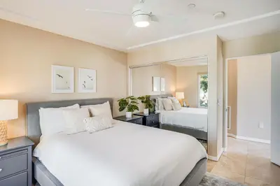 a bedroom with a large white bed and a mirror at Massive Dream Beach Home - Dog Friendly, AC, Steps2Sand in San Diego