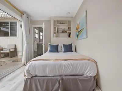 a white bedroom with a large bed in it at Stunning Oceanfront Villa - Massive Patio, Hot Tub, Parking, Pet Friendly & Views! in San Diego
