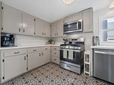 a kitchen with white cabinets and a stove at Stunning Oceanfront Villa - Massive Patio, Hot Tub, Parking, Pet Friendly & Views! in San Diego