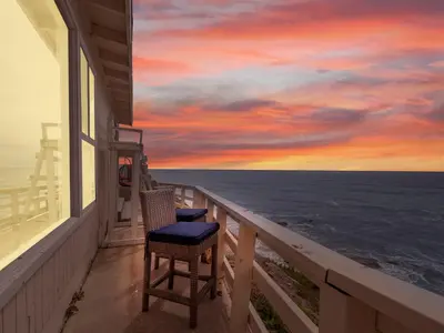 a balcony with two chairs and a view of the ocean at Stunning Oceanfront Villa - Massive Patio, Hot Tub, Parking, Pet Friendly & Views! in San Diego