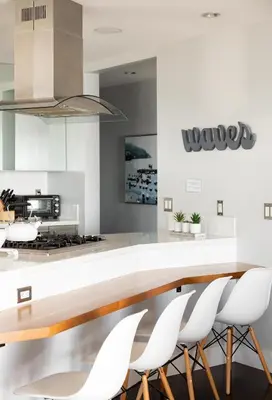 a kitchen with a dining table and white chairs at Oceanfront, two-level condo with stunning view, decks, fast WiFi & fireplace in San Diego