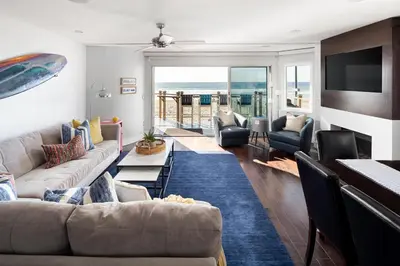 a living room with a couch and chairs and a television at Oceanfront, two-level condo with stunning view, decks, fast WiFi & fireplace in San Diego