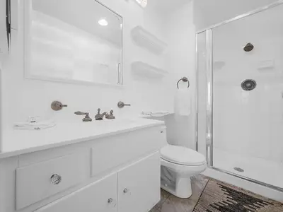 a white bathroom with a toilet and a shower at Sunset Cliffs Lookout - Ocean Front Luxury Condo in San Diego