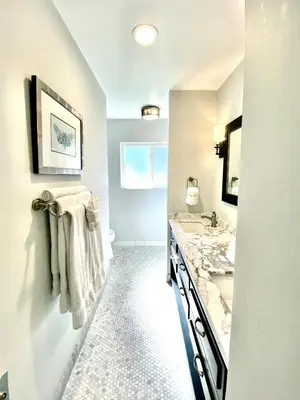 a white bathroom with a sink and a mirror at Endless Vistas On The Cove Perfection - Spa, Pet-Friendly, Stunning Views, Large Parking & AC in San Diego