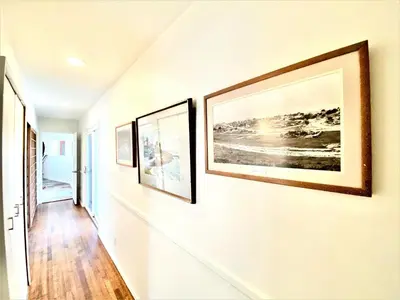 a hallway with three pictures on the wall at Endless Vistas On The Cove Perfection - Spa, Pet-Friendly, Stunning Views, Large Parking & AC in San Diego