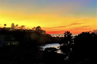 a sunset over a river with palm trees and the ocean at Endless Vistas On The Cove Perfection - Spa, Pet-Friendly, Stunning Views, Large Parking & AC in San Diego