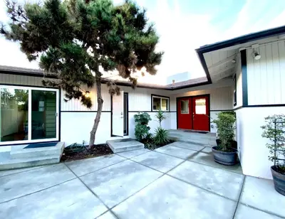 a house with a red door and a tree at Endless Vistas On The Cove Perfection - Spa, Pet-Friendly, Stunning Views, Large Parking & AC in San Diego