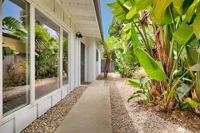a porch of a house with trees and plants at Shores Perfection - Spa, AC, Pet Friendly, Parking, Fire Pit & Massive Private Yard! in San Diego