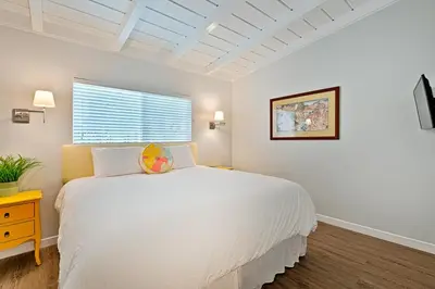 a white bedroom with a large bed and a window at Shores Perfection - Spa, AC, Pet Friendly, Parking, Fire Pit & Massive Private Yard! in San Diego