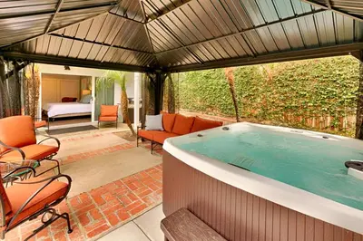 a large hot tub in a room with a patio at Shores Perfection - Spa, AC, Pet Friendly, Parking, Fire Pit & Massive Private Yard! in San Diego