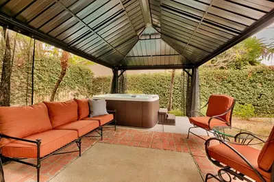 a patio with a couch and a hot tub at Shores Perfection - Spa, AC, Pet Friendly, Parking, Fire Pit & Massive Private Yard! in San Diego