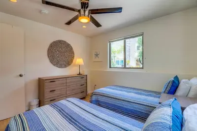 a bedroom with two beds and a ceiling fan at Beach Oasis - Rooftop, Steps2Sand and Water Views in San Diego
