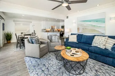 a living room with a blue couch and a table at Oceanfront Home with Stunning View in Oceanside