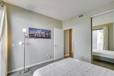 a white bedroom with a bed and a window at Downtown San Diego Condo 1 Mi to Gaslamp Quarter in San Diego
