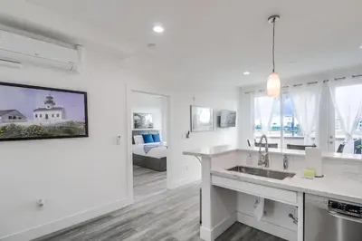 a white kitchen with a sink and a living room at Park Blvd 301 - Modern - Urban Oasis - SPA in San Diego